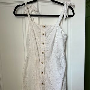 White mini dress with bow sleeves and brown buttons